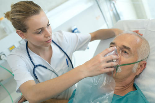 adult male patient in the hospital with oxygen mask